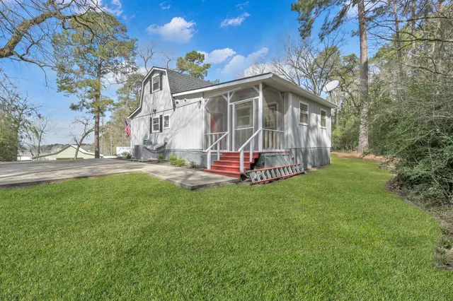 a backyard of a house with wooden fence and large trees