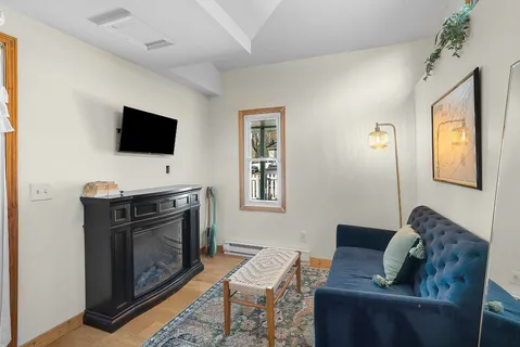 a living room with furniture a flat screen tv and a fireplace