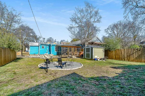 a view of a house with backyard and chairs