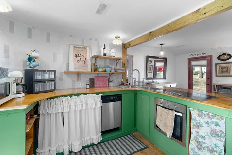 a kitchen with green cabinets a sink and a stove