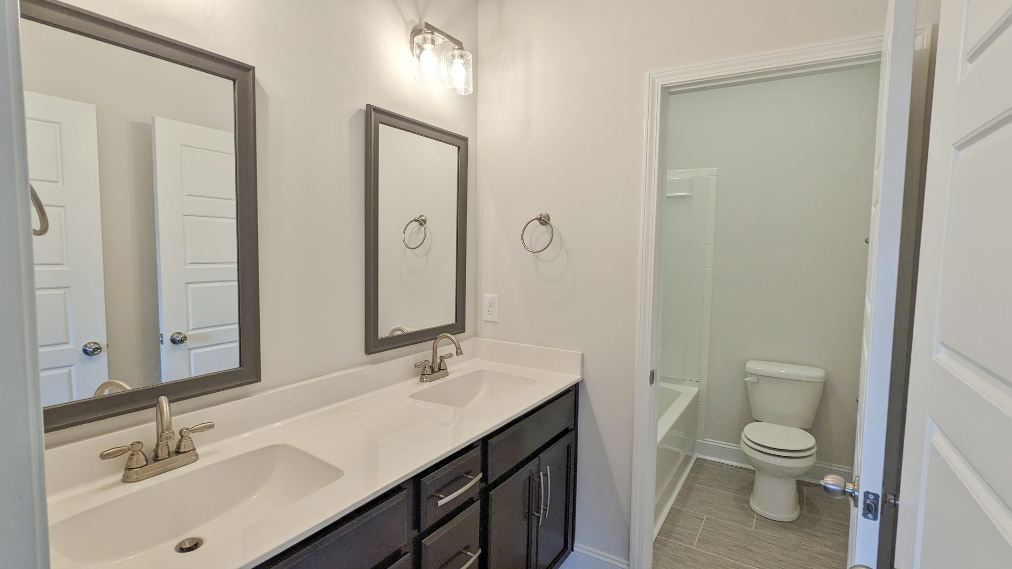 602 Alvin Road Clarksville, TN 37042 - Photo 31 of 39 a bathroom with a toilet a sink a light fixture and a mirror