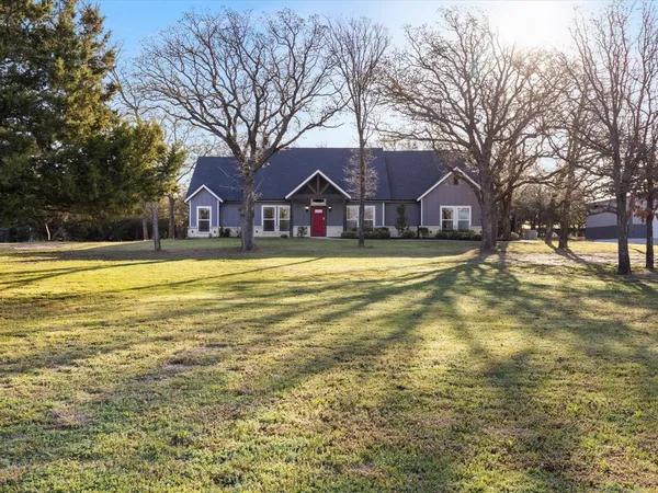 a view of a house with a yard covered with trees