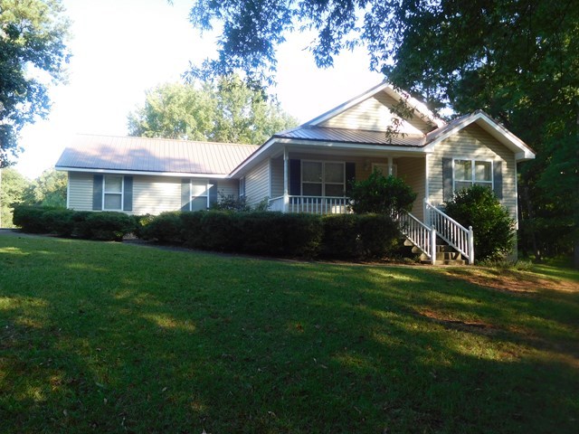 a front view of a house with a yard and green space