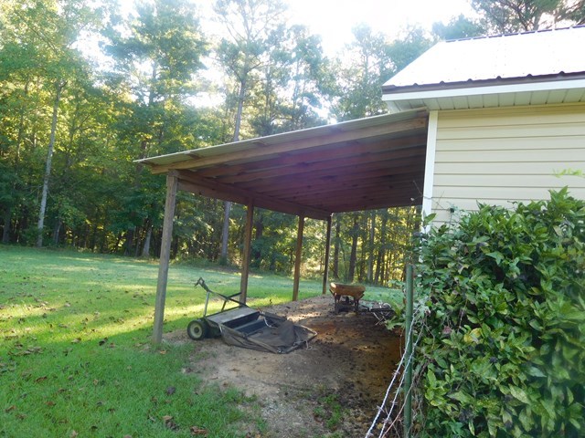 6905 Lower Thomaston Road Macon, GA 31220 - Photo 6 of 18 a view of a small yard with a table and chair under an umbrella