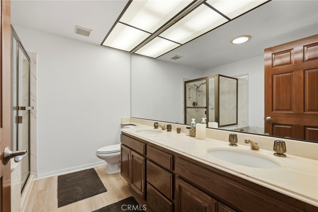 18233 Charlton Lane Porter Ranch, CA 91326 - Photo 17 of 40 a bathroom with a sink a toilet a mirror and shower