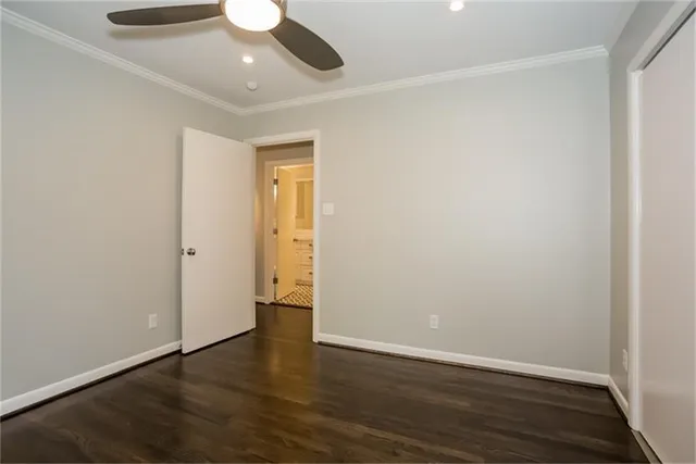 an empty room with wooden floor and ceiling fan