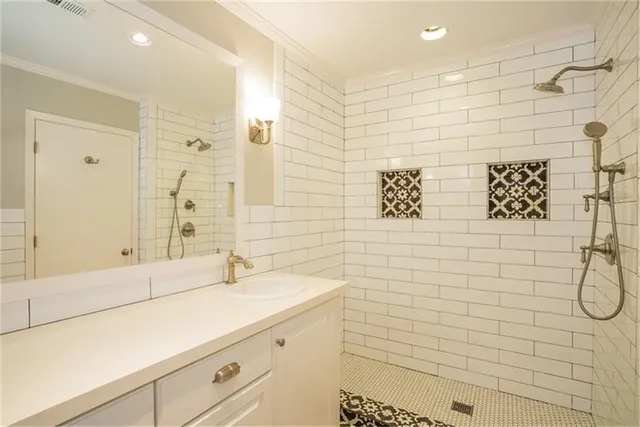 a bathroom with a sink shower and a mirror