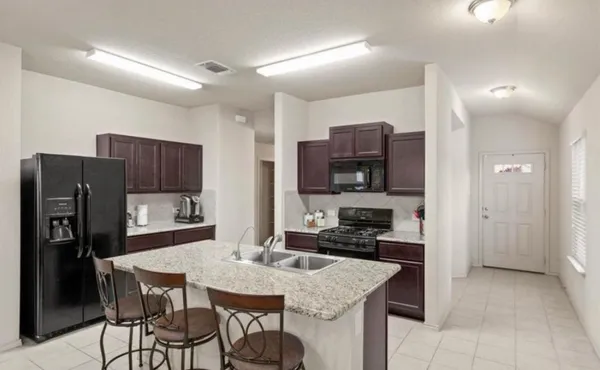 a kitchen with stainless steel appliances granite countertop a stove refrigerator and a refrigerator