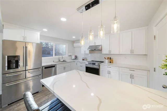 a kitchen with white cabinets and stainless steel appliances