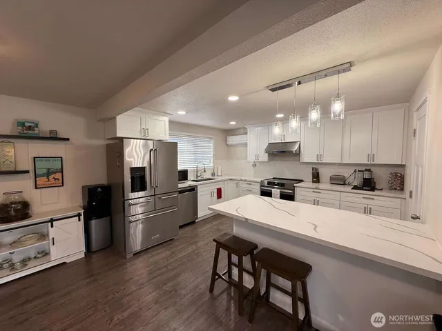 a kitchen with refrigerator cabinets and wooden floor