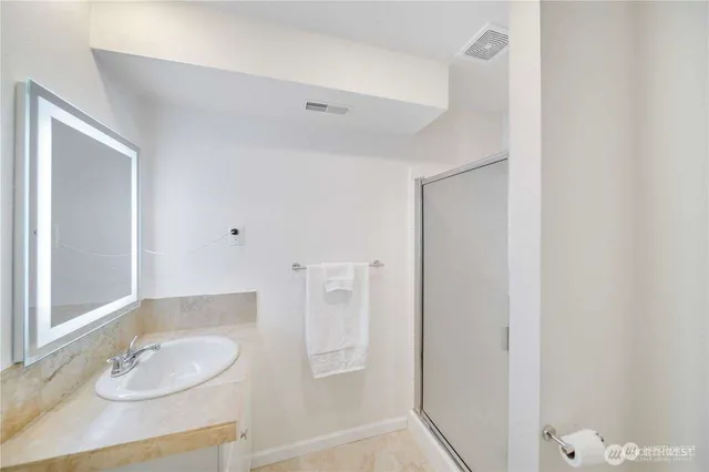 a bathroom with a granite countertop sink and a mirror