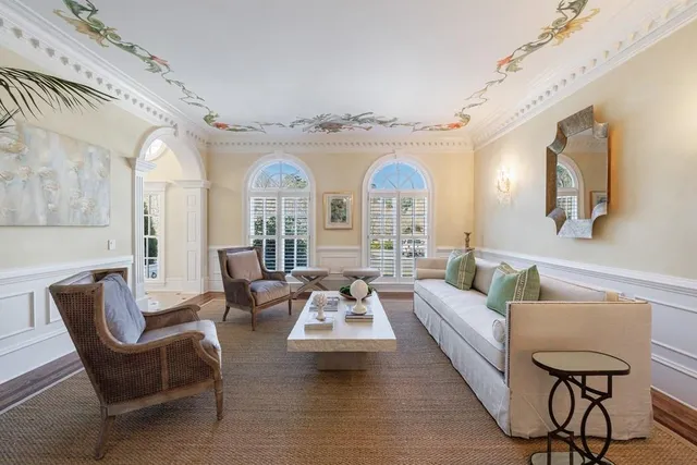 a view of a dining room and livingroom with furniture wooden floor a chandelier