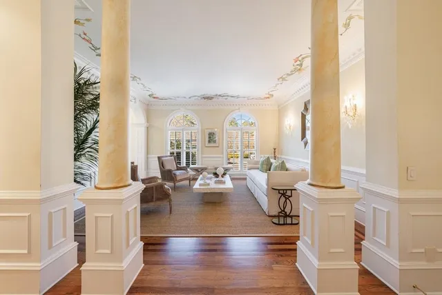 a living room with furniture a chandelier and a fireplace