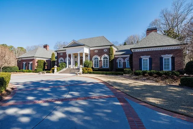 a front view of a house with swimming pool and a yard