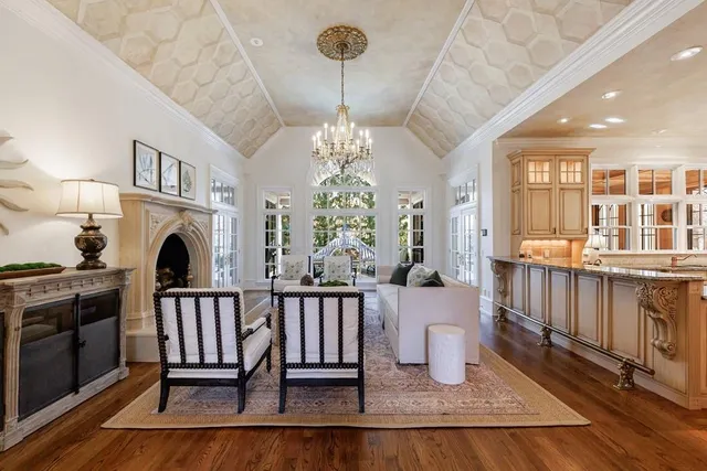 a dining room with wooden floor a chandelier a glass table and windows