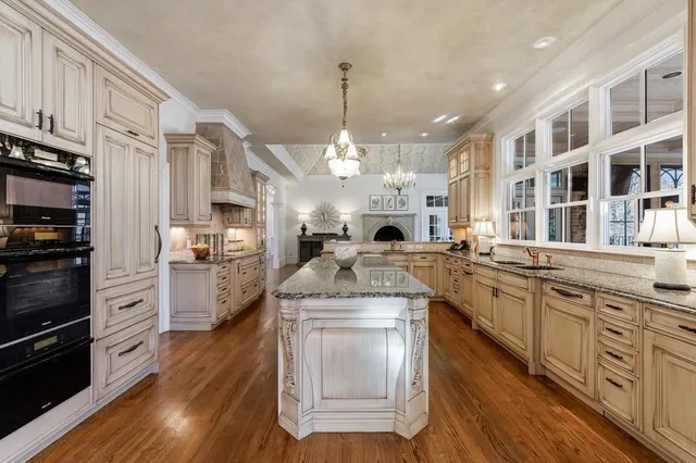 a kitchen with stainless steel appliances granite countertop a sink and a hard wood floor