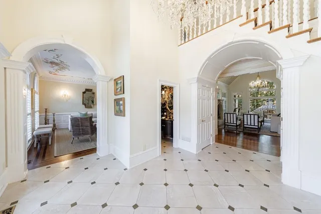 a dining room with furniture a chandelier and wooden floor