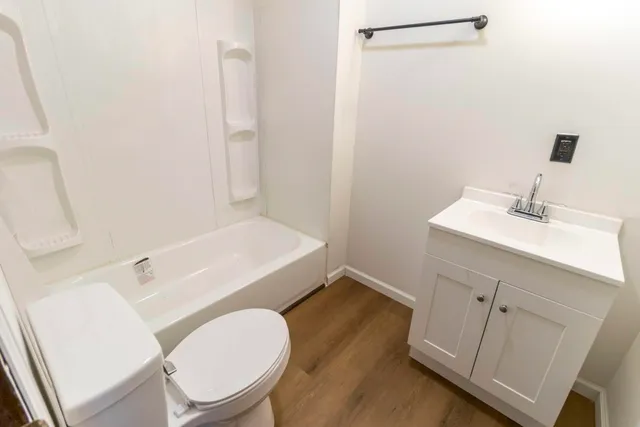 a bathroom with a sink toilet vanity and tub