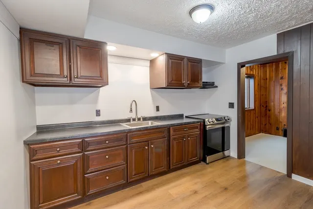 a kitchen with stainless steel appliances granite countertop a stove a sink and a microwave
