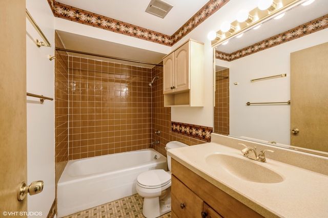 a bathroom with a sink a toilet a mirror a bathtub and shower