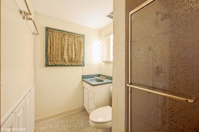 a bathroom with a granite countertop window a toilet and a shower