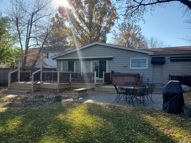 a view of a house with backyard and chairs