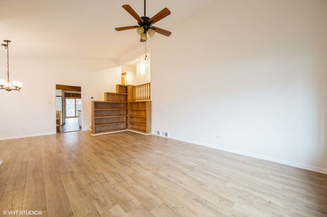 a view of a livingroom with wooden floor and a ceiling fan