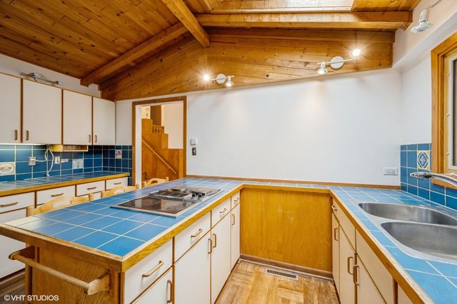 a kitchen with stainless steel appliances granite countertop a sink a stove and white cabinets