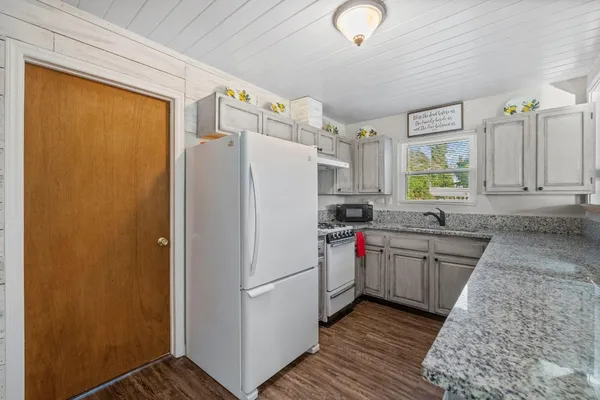a kitchen with granite countertop a refrigerator and a sink