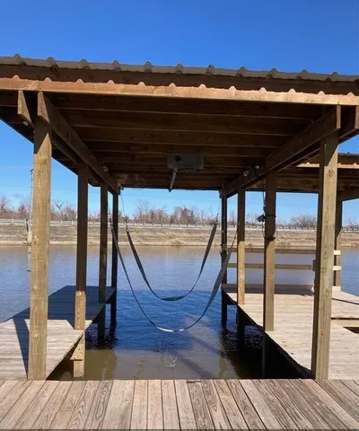 a view of swimming pool with lawn chairs and large trees