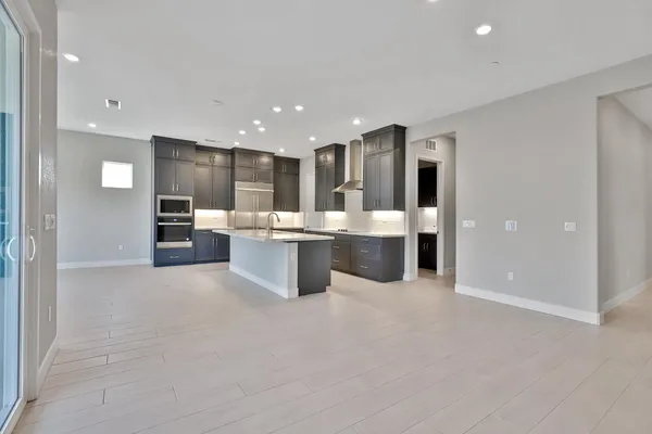 a large white kitchen with a large window and stainless steel appliances