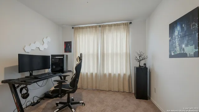 a view of a workspace with furniture and a window