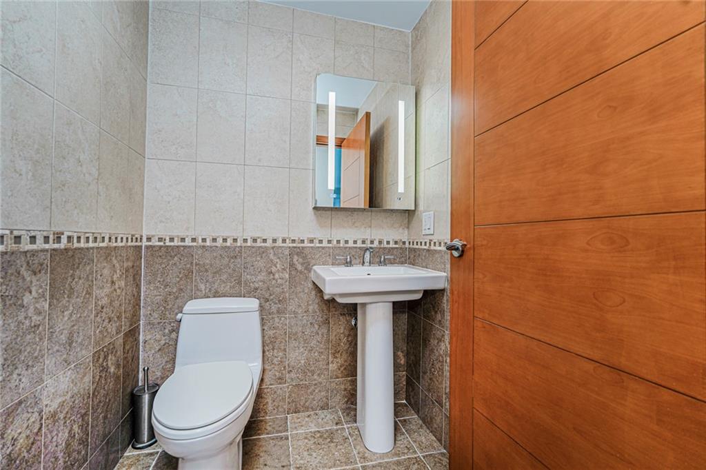 1702 Avenue Z, Unit 6B Brooklyn, NY 11235 - Photo 21 of 40 a bathroom with a toilet a sink and mirror