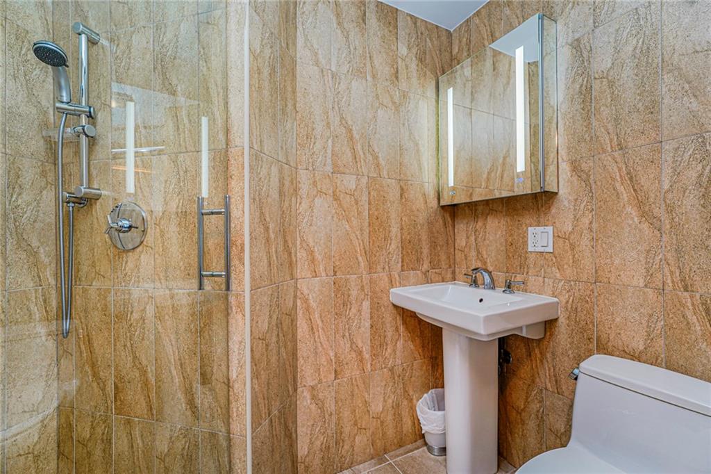 1702 Avenue Z, Unit 6B Brooklyn, NY 11235 - Photo 28 of 40 a bathroom with a sink a toilet and shower