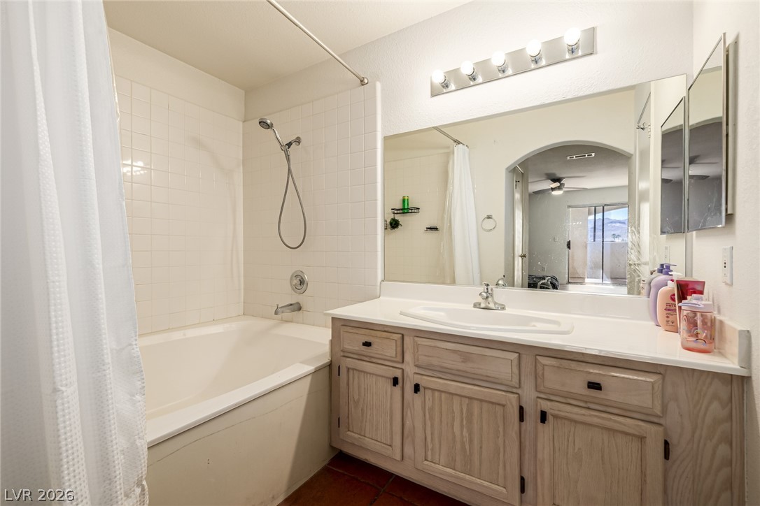 698 South Racetrack Road, Unit 124 Henderson, NV 89015 - Photo 17 of 29 Full bath with vanity, a ceiling fan, shower / bath combination with curtain, dark tile patterned flooring, and ensuite bathroom