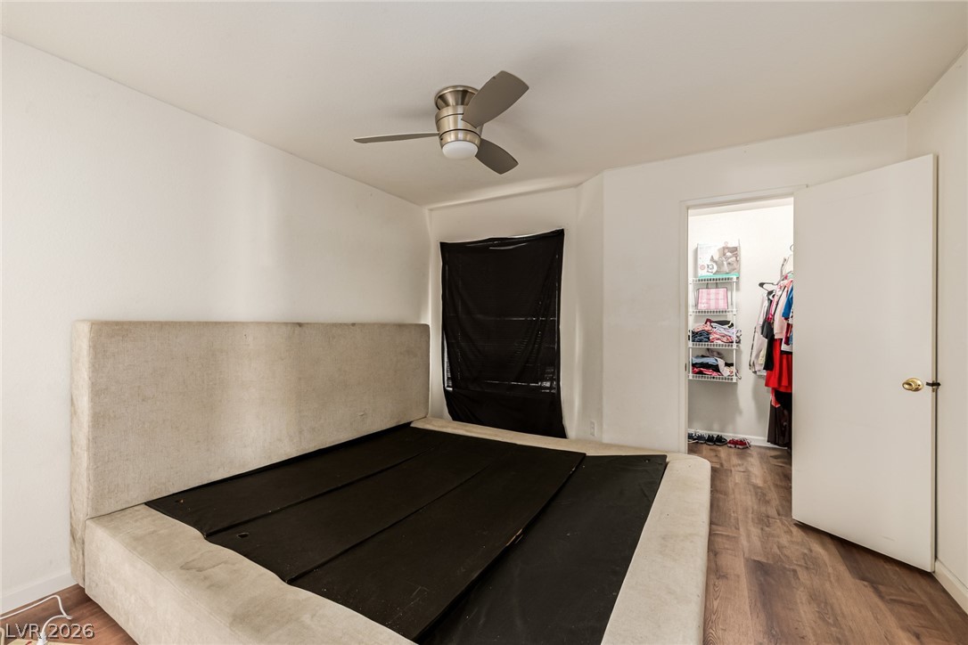 698 South Racetrack Road, Unit 124 Henderson, NV 89015 - Photo 19 of 29 Unfurnished bedroom featuring a walk in closet, wood finished floors, and ceiling fan