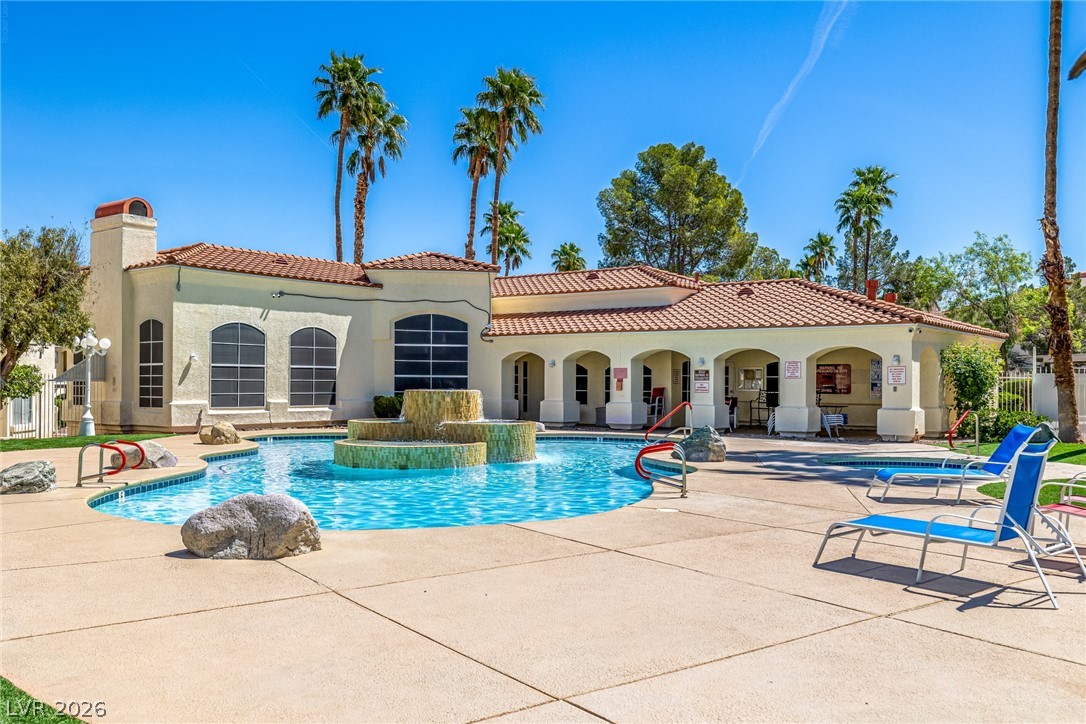 698 South Racetrack Road, Unit 124 Henderson, NV 89015 - Photo 2 of 29 Rear view of house with a community pool, stucco siding, a patio, a chimney, and a tiled roof