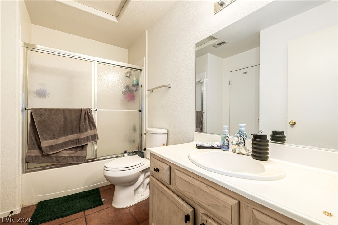 698 South Racetrack Road, Unit 124 Henderson, NV 89015 - Photo 21 of 29 Full bathroom featuring vanity, enclosed tub / shower combo, and dark tile patterned floors