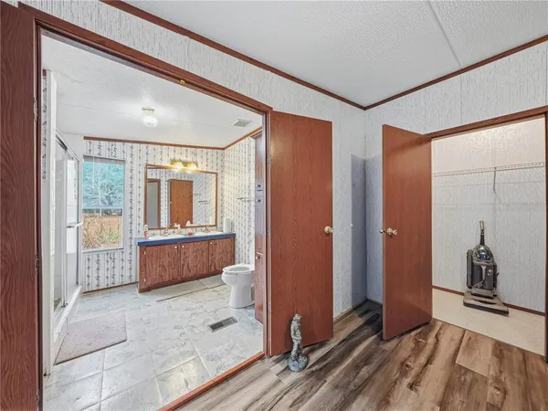 a view of a bedroom with wooden floor and balcony