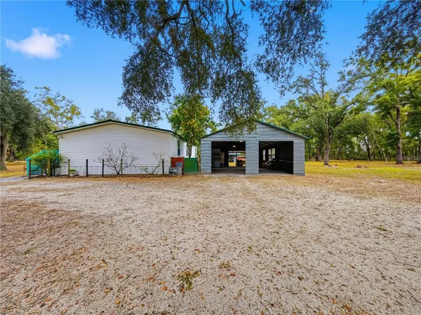 a view of a house with backyard and a tree