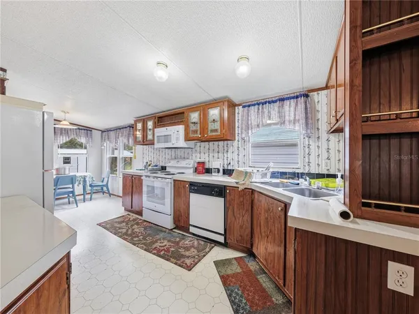 a kitchen with stainless steel appliances granite countertop a stove a sink dishwasher and a refrigerator