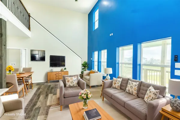 a living room with furniture and large windows