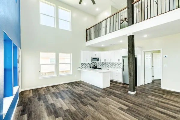 a view of a hallway with wooden floor and staircase