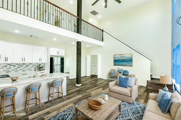 a living room with furniture kitchen view and a large window