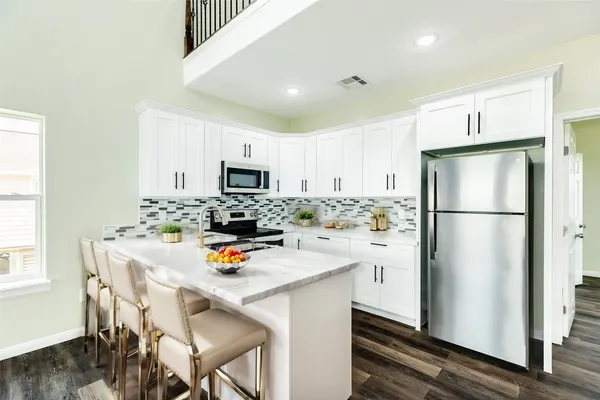 a kitchen with stainless steel appliances a refrigerator stove microwave and cabinets