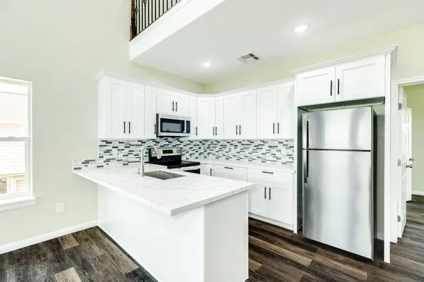 a kitchen with a refrigerator a sink and a microwave