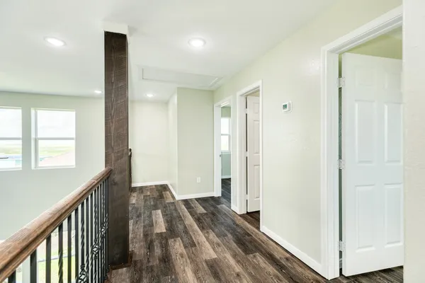 a view of a hallway with wooden floor and staircase
