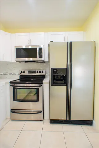 a kitchen with a refrigerator and a stove