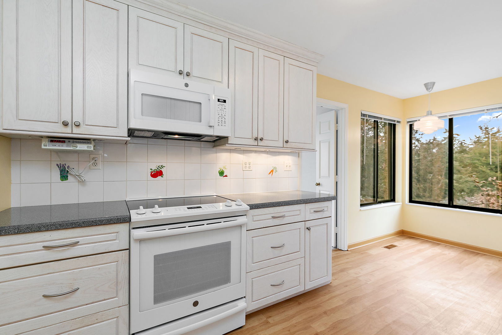 25 Shoreline Road, Unit D Lake Barrington, IL 60010 - Photo 11 of 43 a kitchen with granite countertop white cabinets and white appliances