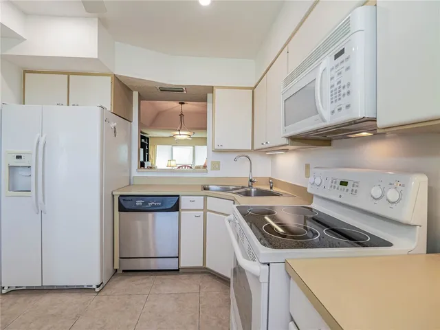 a kitchen with stainless steel appliances granite countertop a sink a stove a refrigerator and a refrigerator